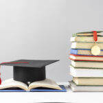 front-view-stacked-books-graduation-cap-open-book-education-day